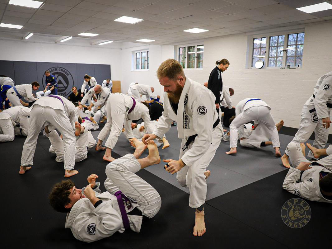 Adult students training together at RGA Buckingham, smiling and enjoying a friendly Jiu-Jitsu session on the mats.